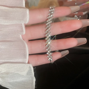 Close-up of sparkling diamond-encrusted silver pull-out bracelet on a hand model