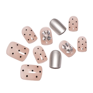 Short nude press-on nails with silver glitter, black dots, and metallic foil finish