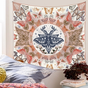Detail of bohemian mandala tapestry featuring antler moth and floral patterns over a bed