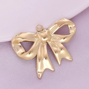 Macro shot of a polished gold 304 stainless steel bow pendant with a glossy finish