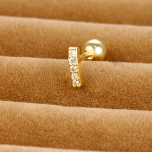 Macro shot of gold-plated stainless steel cartilage stud with five white cubic zirconias