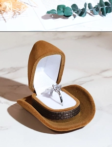 Detailed close-up view of creative cowboy hat shaped ring box with soft velvet lining.