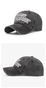 Close-up of 3D embroidery and washed vintage texture on a grey cotton baseball cap
