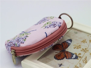 Detail of pink floral fabric coin purse with semicircular zipper and metal keychain