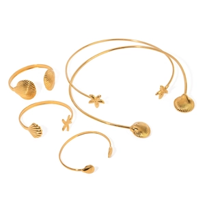 Polished gold stainless steel jewelry set featuring starfish and seashell charms