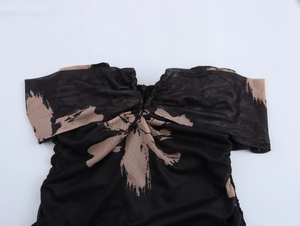 Dettaglio del top in mesh con spalle scoperte, stampa astratta e scollatura a pieghe