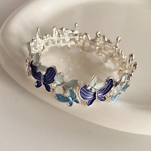 Detailed macro view of the blue enamel butterfly charm with gradient texture and crystals