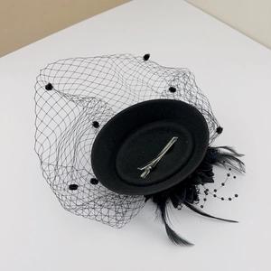 Detail view of black vintage mini hat with polka dot mesh veil and feather decor
