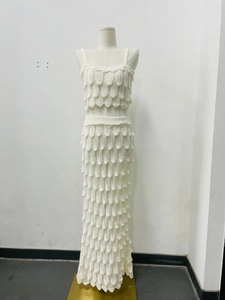 Detail of white two-piece set featuring fish-scale knit texture on top and slim-fit skirt