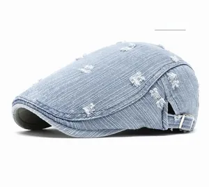 Detail of light blue washed denim beret featuring distressed ripped edges and metal buckle