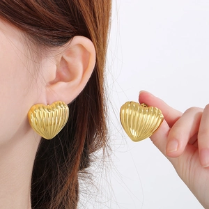 Detail showing 18K gold plated heart stud earrings with unique vertical striped texture