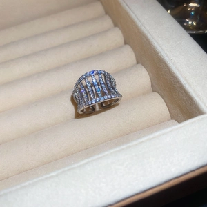 Close-up of sparkling silver hollow cage ring with clear zircon stones on velvet