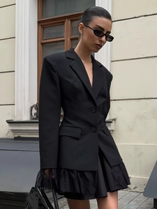 Close-up of black tailored blazer featuring intricate lace hem and flap pocket details