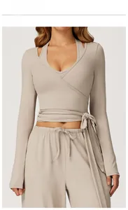 Detailed view of linen colored yoga set featuring cross-strap top and wide-leg trousers