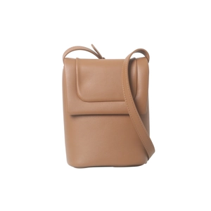 Gros plan sur un sac à bandoulière minimaliste en cuir marron avec fermeture à rabat chic