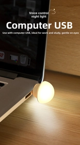 Macro shot of warm yellow voice-controlled USB night light plugged into a laptop