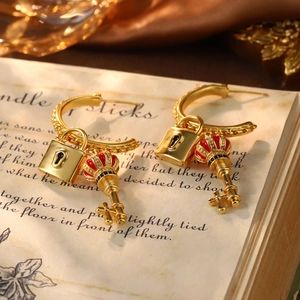 Detail of vintage gold hoop earrings with red enamel crown key and lock charms