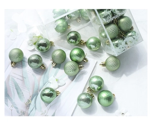 Detail of green Christmas balls in glossy and matte finishes within a gift set box