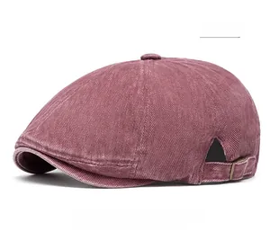 Detail of red corduroy newsboy cap with textured fabric and vintage metal side buckle