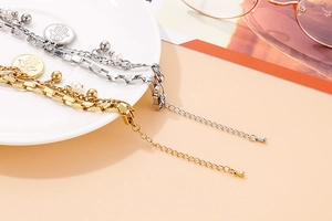 Close-up of double-layer titanium Hamsa hand bracelet with pearls in gold and silver