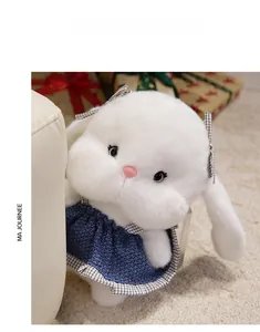 Detail of cute white plush bunny wearing blue knitted dress and checkered bow decoration