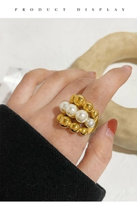 Detailed macro view of a multi-layer gold beaded ring featuring white pearls in center