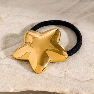 Gold star stainless steel hair tie with black high-elastic band on marble background