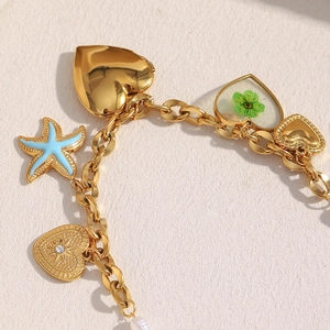 Detail der 18K vergoldeten Anhänger mit Seestern, Herz und Kleeblatt an der Kette