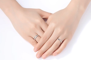 Close-up of minimalist couple rings with zircon stones on silver metal band