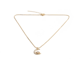 Détail du collier doré avec pendentif lune et étoile orné de zircons cubiques