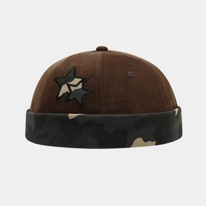 Detail view of corduroy docker hat featuring star embroidery and camouflage cuff design