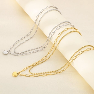 Detail of double-layered stainless steel necklace with heart pendant and paperclip chain