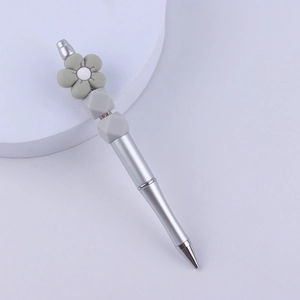 Close-up of silver DIY beaded pen with grey silicone flower and geometric bead accents