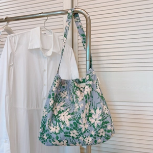 Dettaglio della borsa tote floreale in tela con fiori bianchi ed etichetta Simple Wish
