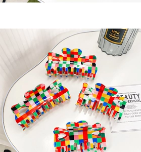 Close-up of retro colorful checkerboard hair claws with hollow heart design on a table