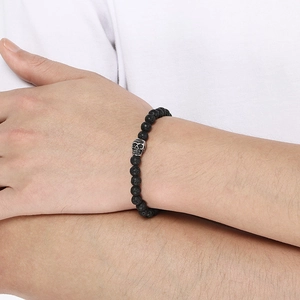 Lava stone elastic bracelet featuring a vintage silver skull charm on a wrist