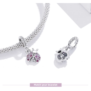 Detail of s925 silver ladybug charm with pink zircon stones on a chain bracelet