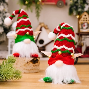 Gros plan de gnomes de Noël tricotés rouges et verts avec cloches dans un décor festif