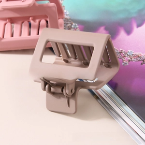 Detail of matte square hair claw clips in brown and pink colors with sturdy spring mechanism