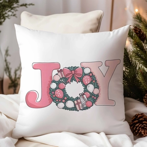 Close-up of Christmas pillow cover with pink JOY text and festive wreath pattern