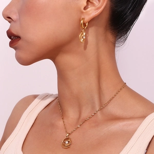 Retro evil eye and sunburst jewelry set with gold finish and zircons on a model