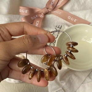 Detailed shot of retro silver hoop earrings with amber resin beads on fabric