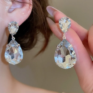 Close-up of sparkling clear crystal teardrop earrings with a silver metal finish