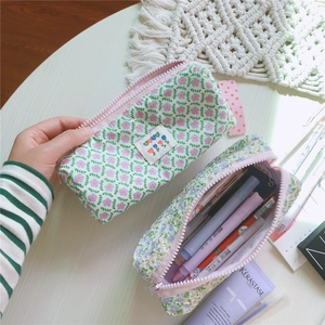 Primer plano detallado del estuche floral de lona con cremallera rosa y tela lavanda