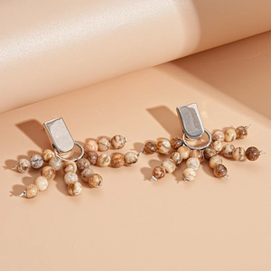 Close-up of vintage earrings with brown marble beads and silver rectangle studs