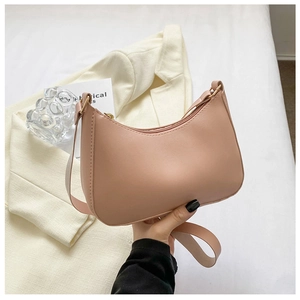 Detail of soft dusty pink PU leather texture and golden metal zipper on hobo bag
