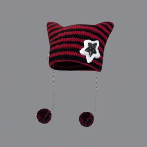 Striped knit beanie with cat ears, red and black pattern with white star patch and pom-poms