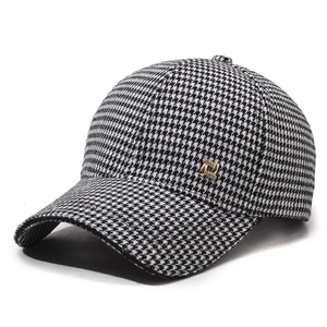 Classic black and white houndstooth baseball cap with elegant gold metal accent