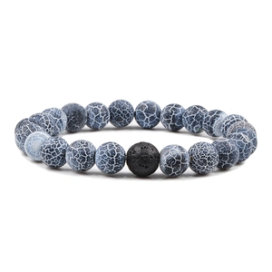 Détail macro du bracelet élastique avec perles d'agate bleue et pierre de lave noire