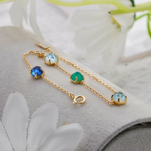 Macro shot of 14k gold-plated silver bracelet featuring multi-colored gemstones and spring clasp